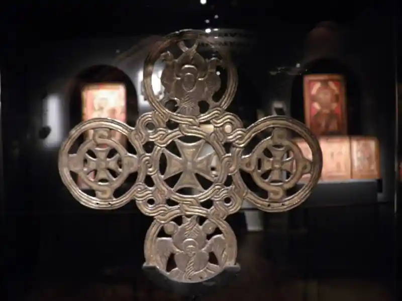 A cross composed of solar discs with crosses inside and winged man on top and at the bottom.